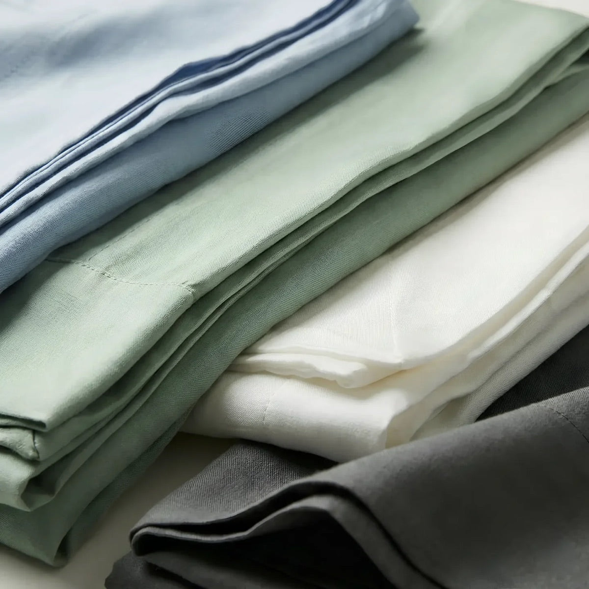 Folded TENCEL Lyocell pillowcases in blue, green, white and grey